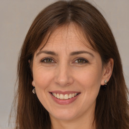 Joyful white adult female with long  brown hair and brown eyes