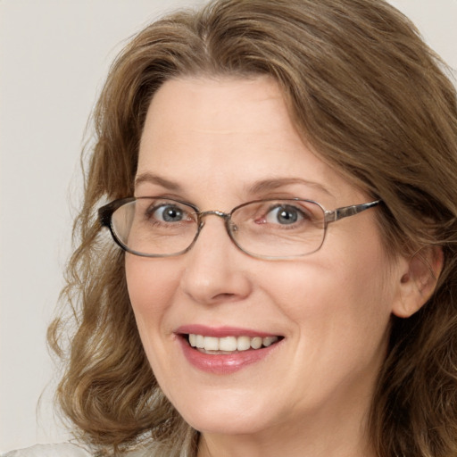 Joyful white adult female with medium  brown hair and blue eyes