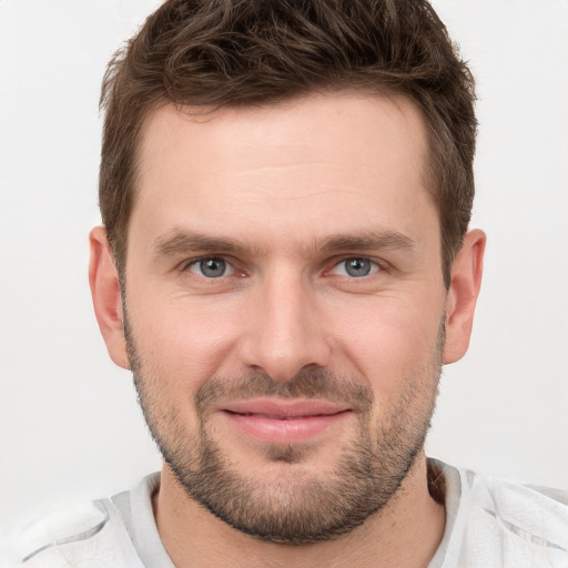 Joyful white young-adult male with short  brown hair and grey eyes