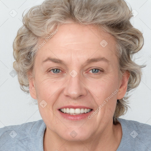 Joyful white adult female with medium  brown hair and blue eyes