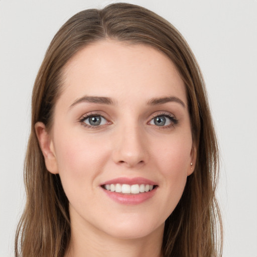 Joyful white young-adult female with long  brown hair and grey eyes