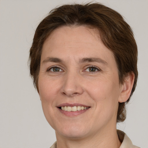 Joyful white adult female with medium  brown hair and grey eyes