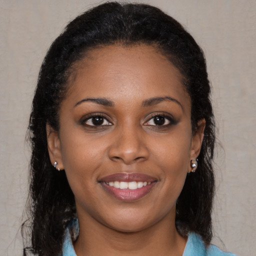 Joyful black young-adult female with long  brown hair and brown eyes