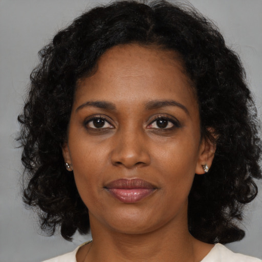 Joyful black young-adult female with medium  brown hair and brown eyes
