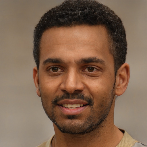Joyful black young-adult male with short  black hair and brown eyes