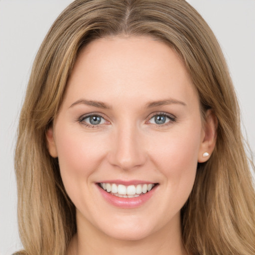 Joyful white young-adult female with long  brown hair and green eyes