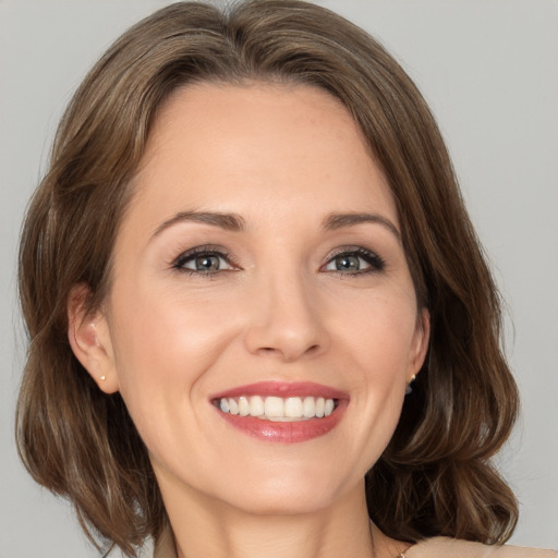 Joyful white young-adult female with medium  brown hair and grey eyes