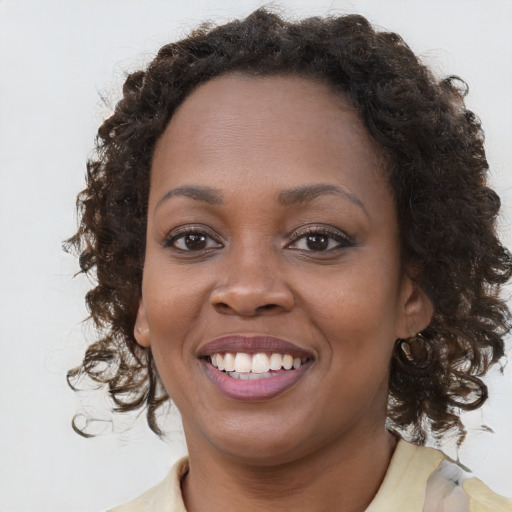 Joyful black young-adult female with medium  brown hair and brown eyes