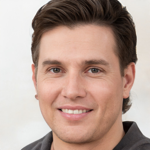 Joyful white young-adult male with short  brown hair and grey eyes