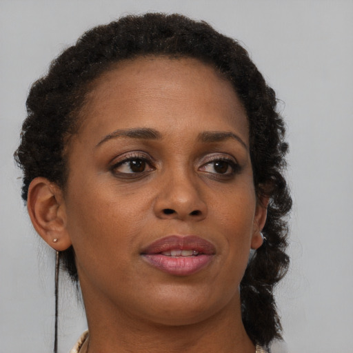 Joyful black adult female with medium  brown hair and brown eyes