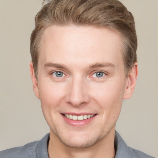 Joyful white young-adult male with short  brown hair and grey eyes