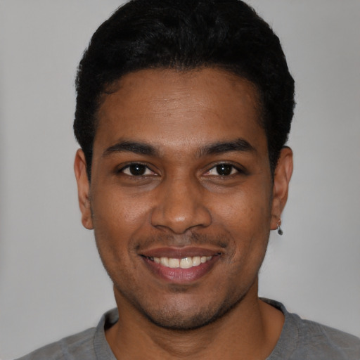 Joyful black young-adult male with short  black hair and brown eyes