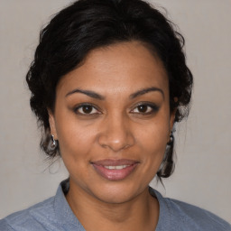 Joyful black young-adult female with medium  brown hair and brown eyes