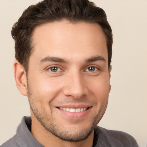 Joyful white young-adult male with short  brown hair and brown eyes