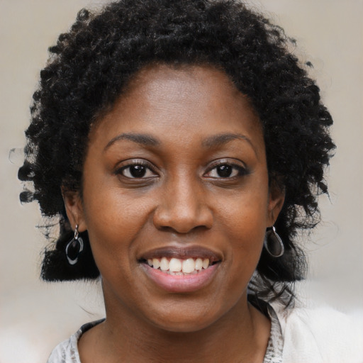 Joyful black young-adult female with short  black hair and brown eyes