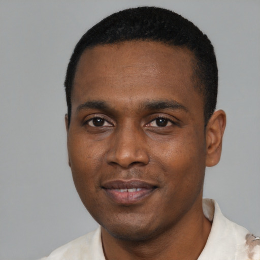 Joyful black young-adult male with short  black hair and brown eyes