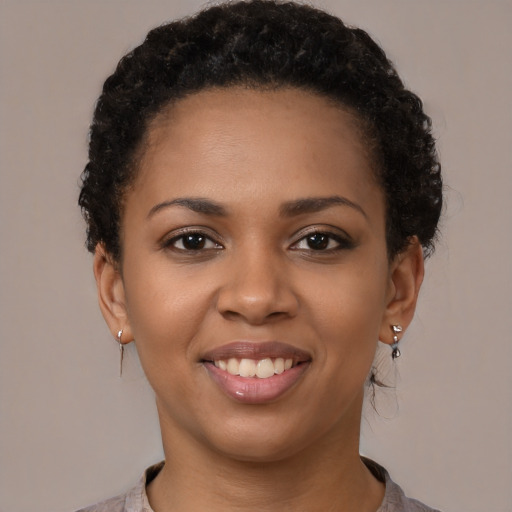 Joyful black young-adult female with short  brown hair and brown eyes