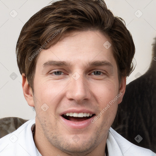 Joyful white young-adult male with short  brown hair and grey eyes