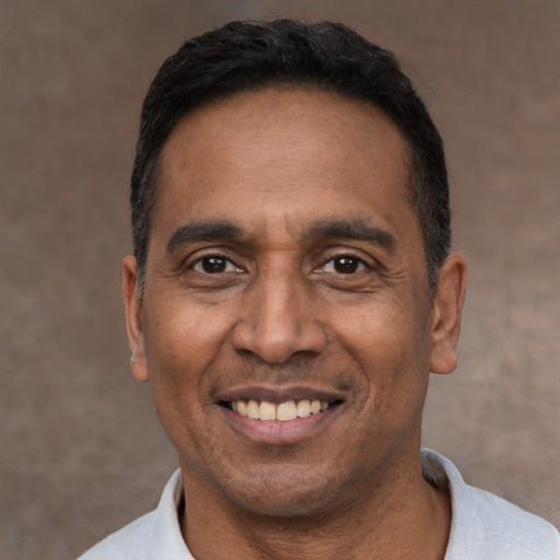 Joyful latino adult male with short  black hair and brown eyes