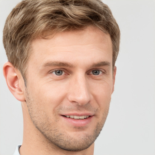 Joyful white young-adult male with short  brown hair and grey eyes