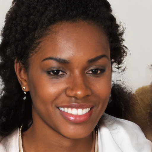 Joyful black young-adult female with long  brown hair and brown eyes