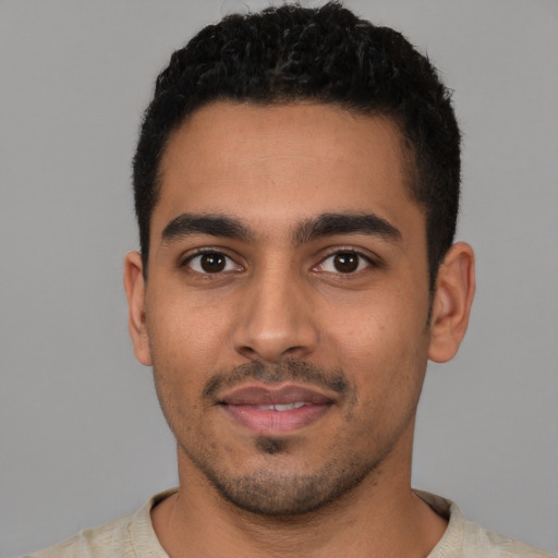 Joyful latino young-adult male with short  black hair and brown eyes