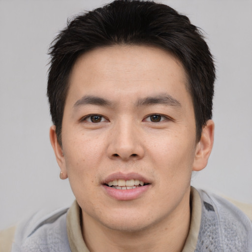 Joyful asian young-adult male with short  brown hair and brown eyes
