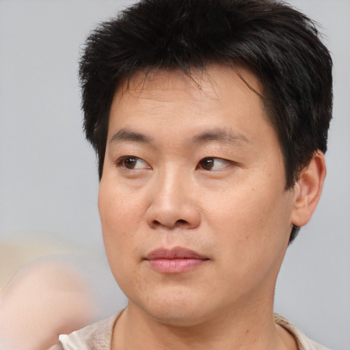 Joyful asian young-adult male with short  brown hair and brown eyes