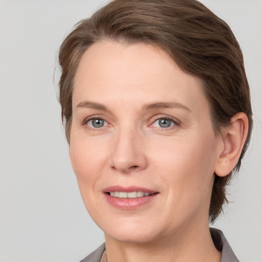 Joyful white adult female with medium  brown hair and grey eyes