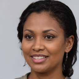 Joyful black young-adult female with long  brown hair and brown eyes