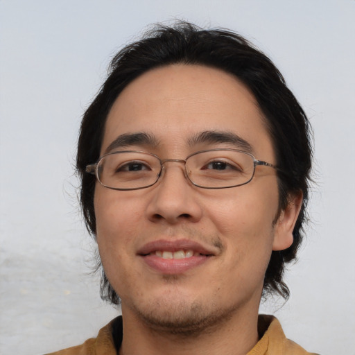 Joyful asian young-adult male with medium  brown hair and brown eyes