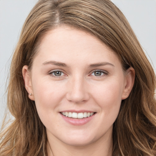 Joyful white young-adult female with long  brown hair and grey eyes