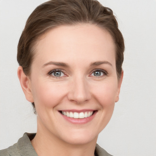 Joyful white young-adult female with short  brown hair and grey eyes