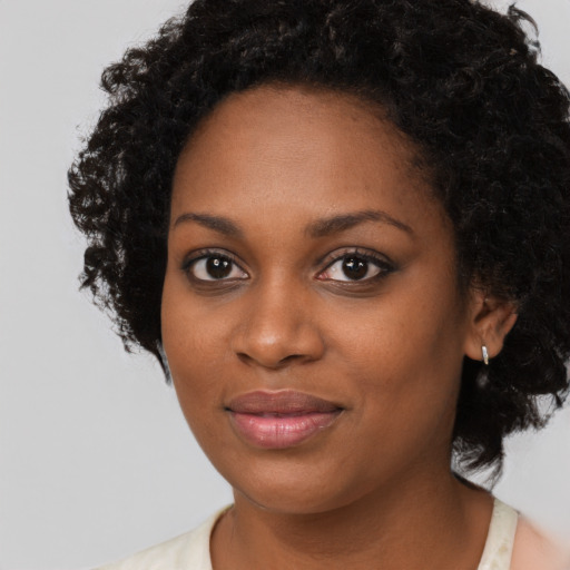 Joyful black young-adult female with short  black hair and brown eyes