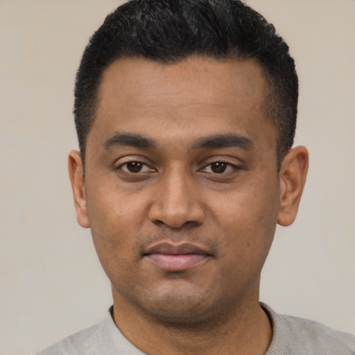 Joyful latino young-adult male with short  black hair and brown eyes