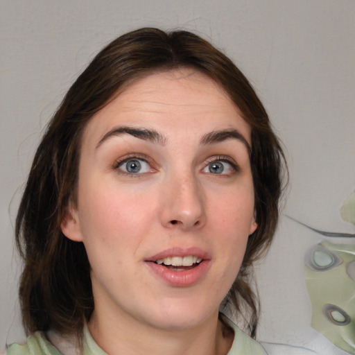 Joyful white young-adult female with medium  brown hair and green eyes