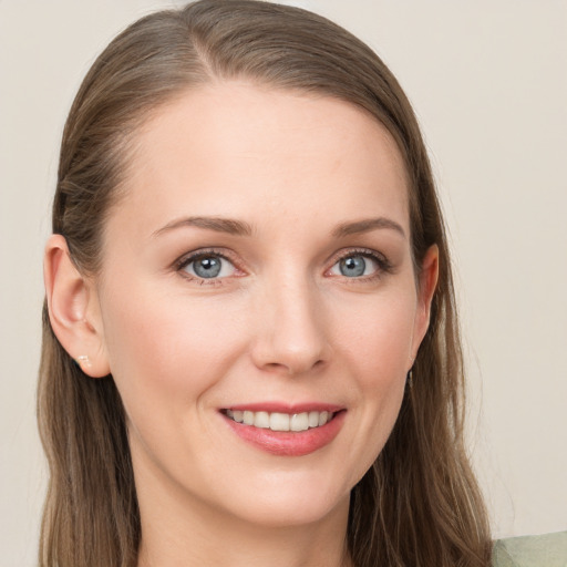 Joyful white young-adult female with long  brown hair and blue eyes