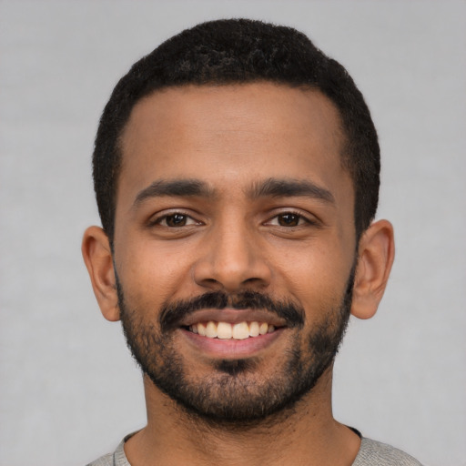 Joyful latino young-adult male with short  black hair and brown eyes