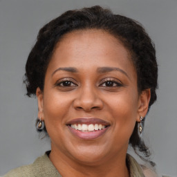 Joyful black adult female with medium  brown hair and brown eyes