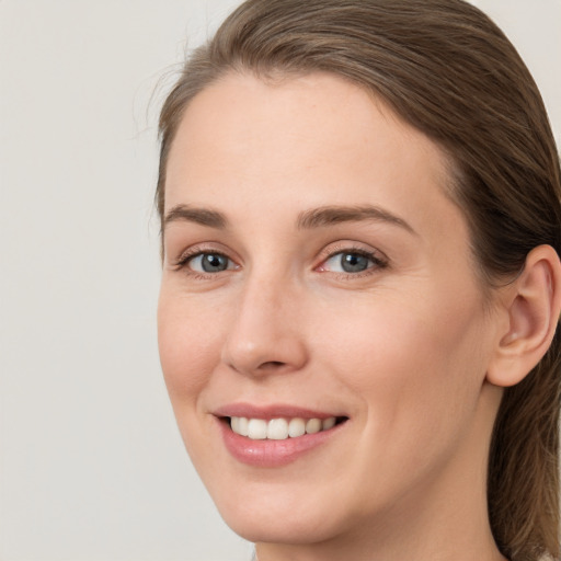 Joyful white young-adult female with long  brown hair and green eyes