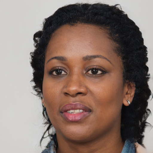 Joyful black young-adult female with long  black hair and brown eyes