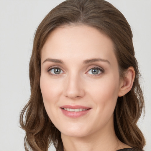 Joyful white young-adult female with long  brown hair and blue eyes