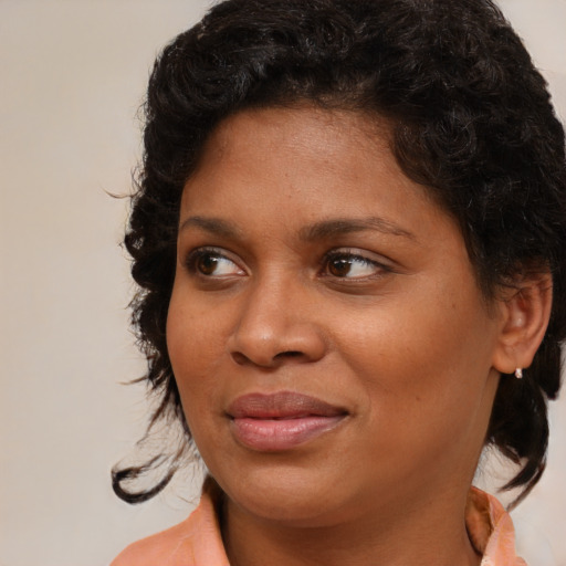 Joyful black young-adult female with medium  brown hair and brown eyes