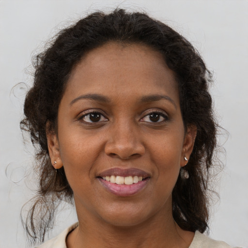 Joyful black young-adult female with medium  brown hair and brown eyes
