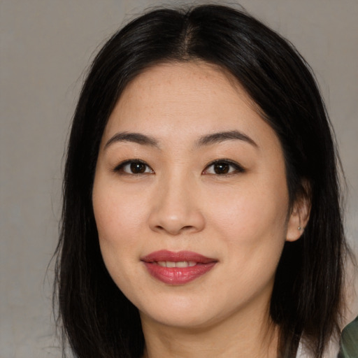 Joyful asian young-adult female with long  brown hair and brown eyes