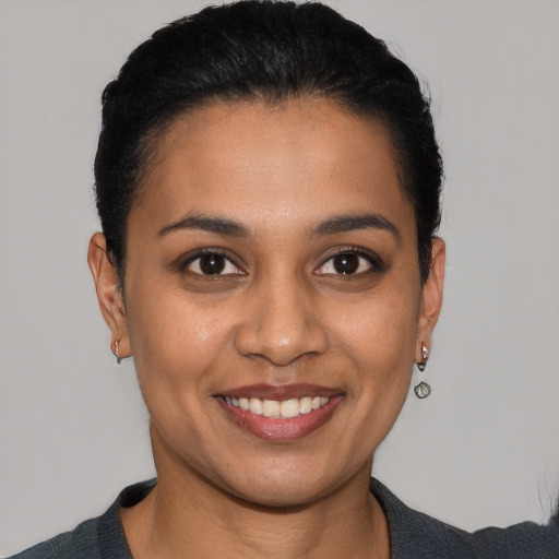 Joyful latino young-adult female with short  black hair and brown eyes