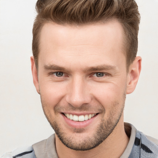 Joyful white young-adult male with short  brown hair and grey eyes