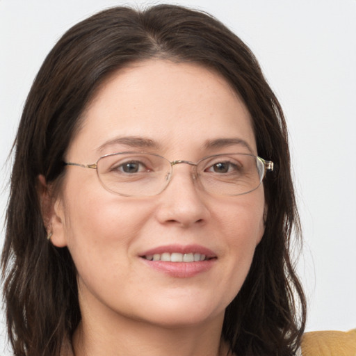 Joyful white adult female with long  brown hair and grey eyes