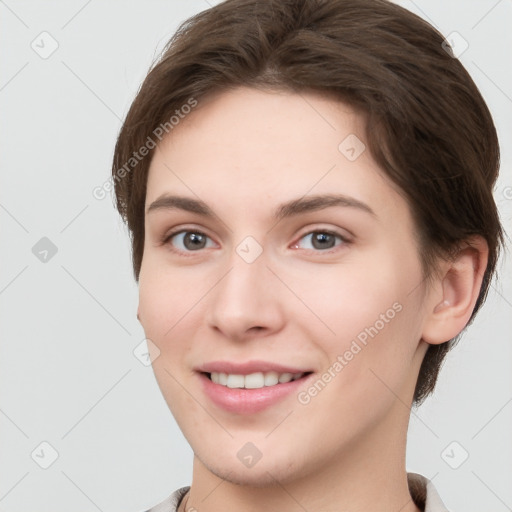 Joyful white young-adult female with short  brown hair and grey eyes