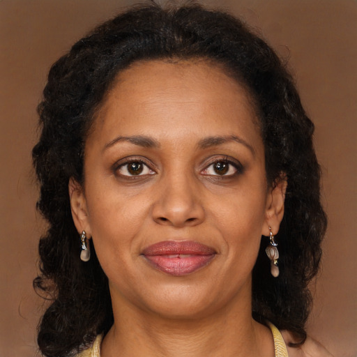 Joyful black adult female with long  brown hair and brown eyes